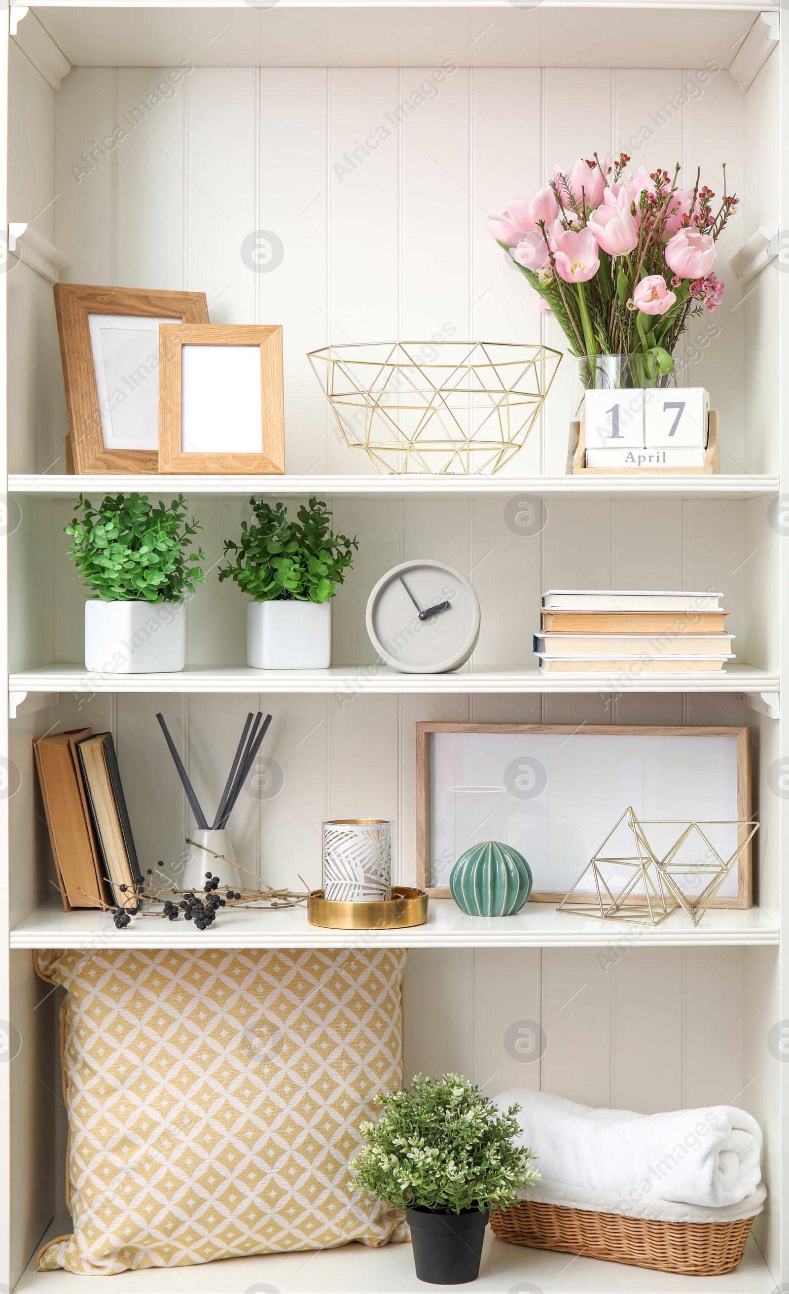 Photo of White shelving unit with plants and different decorative stuff