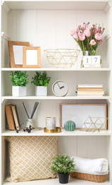 White shelving unit with plants and different decorative stuff