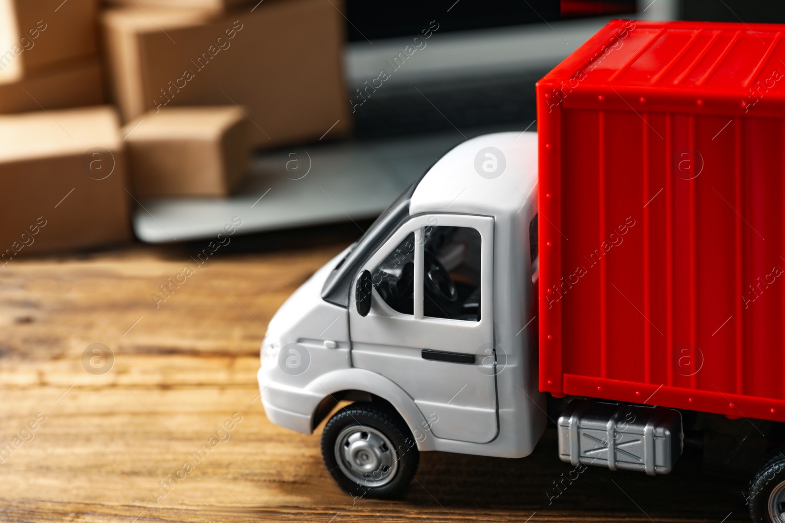 Photo of Toy truck on wooden table. Logistics and wholesale concept