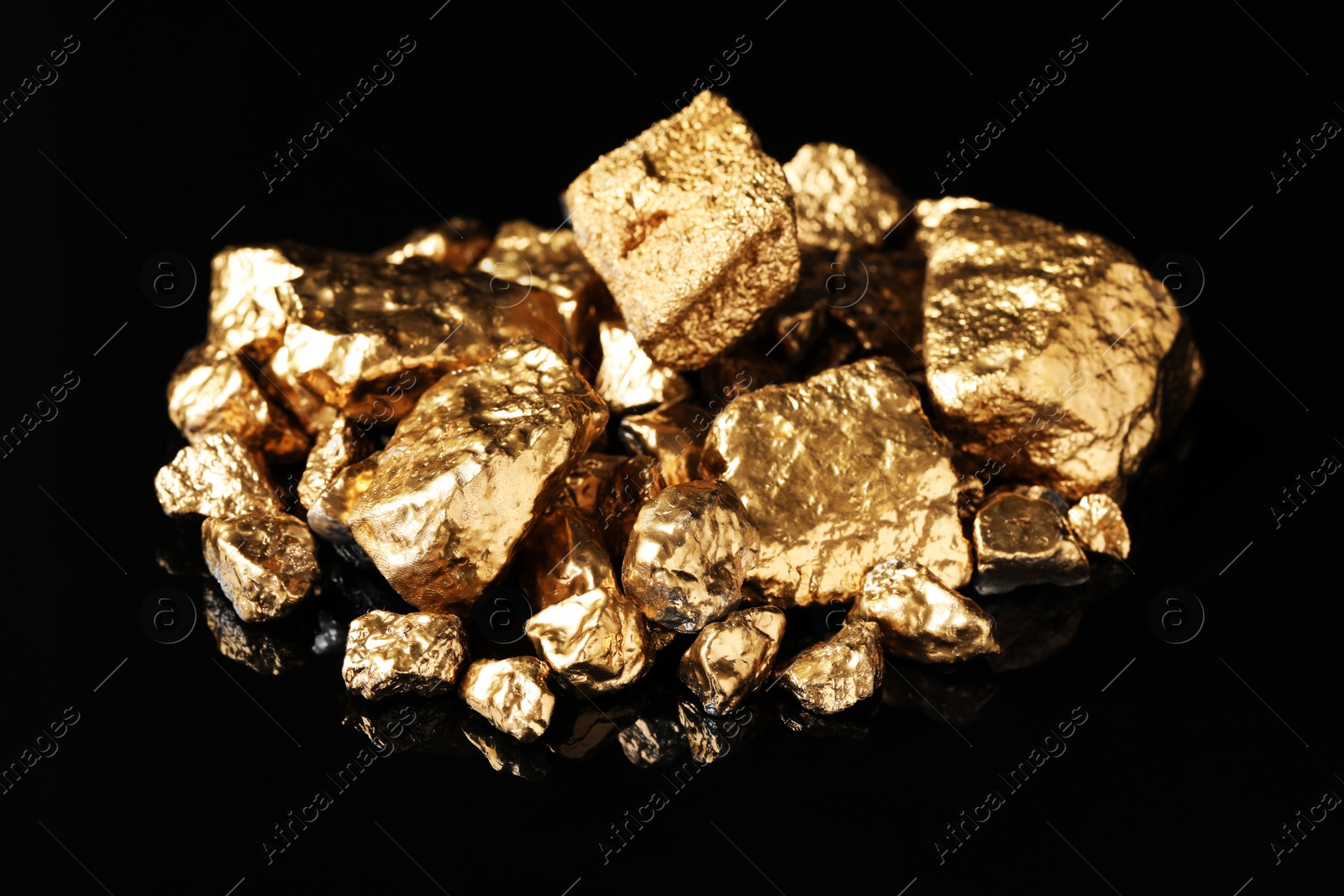 Photo of Pile of shiny gold nuggets on black background