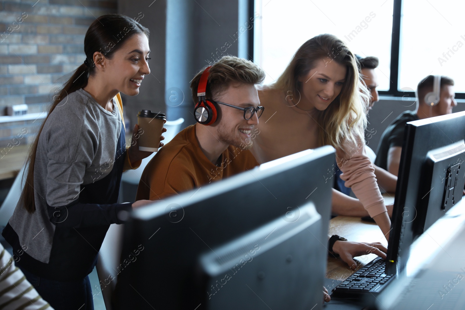 Photo of Group of people playing video games in internet cafe