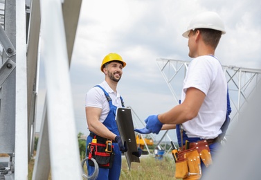Workers building high voltage tower construction outdoors. Installation of electrical substation
