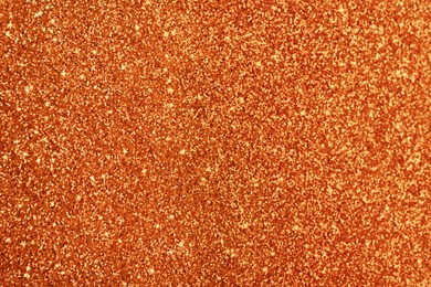 Beautiful shiny orange glitter as background, closeup