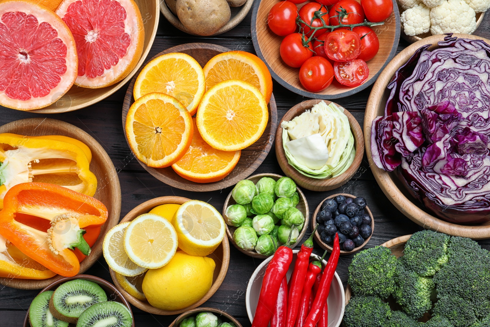 Photo of Different products rich in vitamin C on wooden table, flat lay