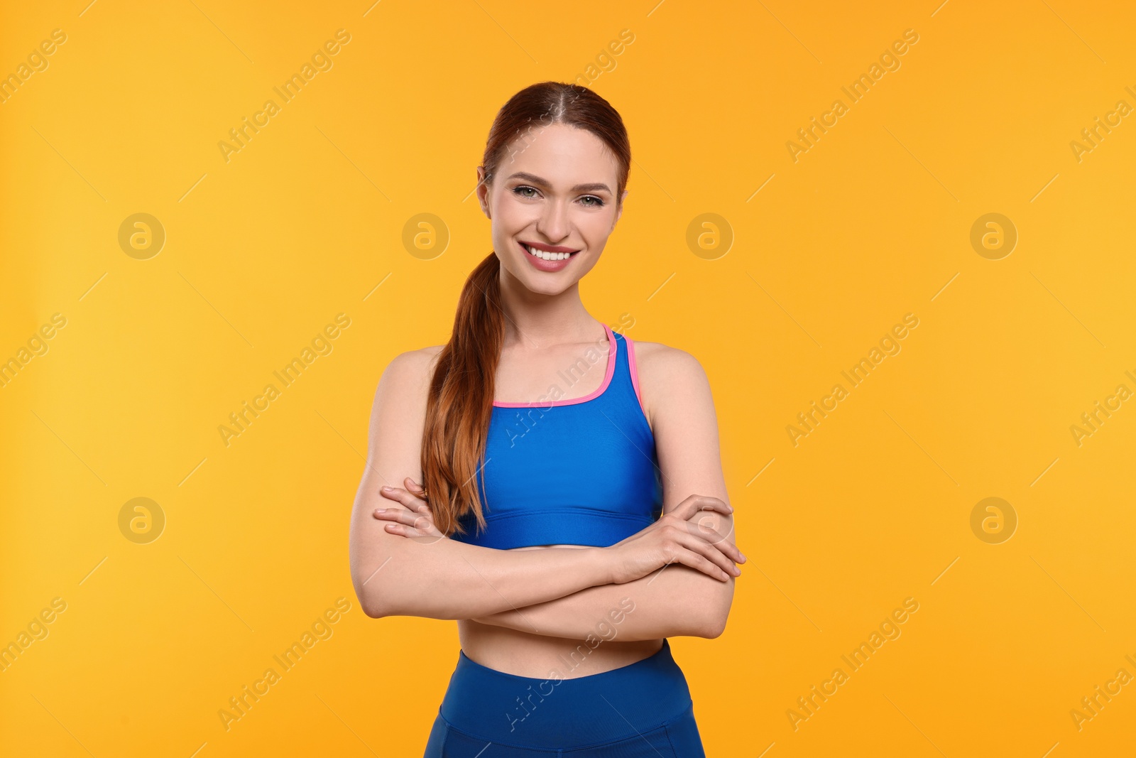 Photo of Young woman wearing sportswear on yellow background