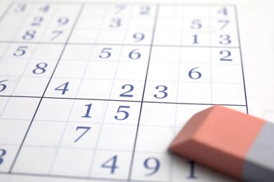 Photo of Sudoku puzzle grid and eraser, closeup view