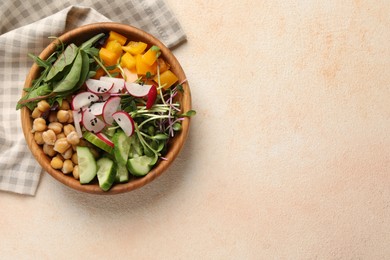 Photo of Delicious vegan bowl with cucumbers, chickpeas and radish on beige table, top view. Space for text