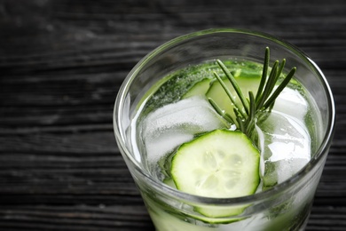 Photo of Glass of fresh cucumber water on wooden table, closeup