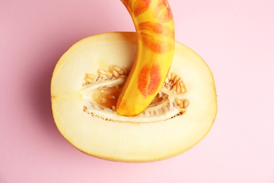 Flat lay composition with fresh banana and melon on pink background. Sex concept