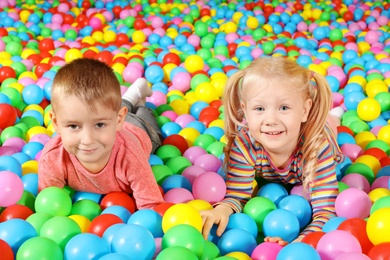 Cute children playing in ball pit indoors