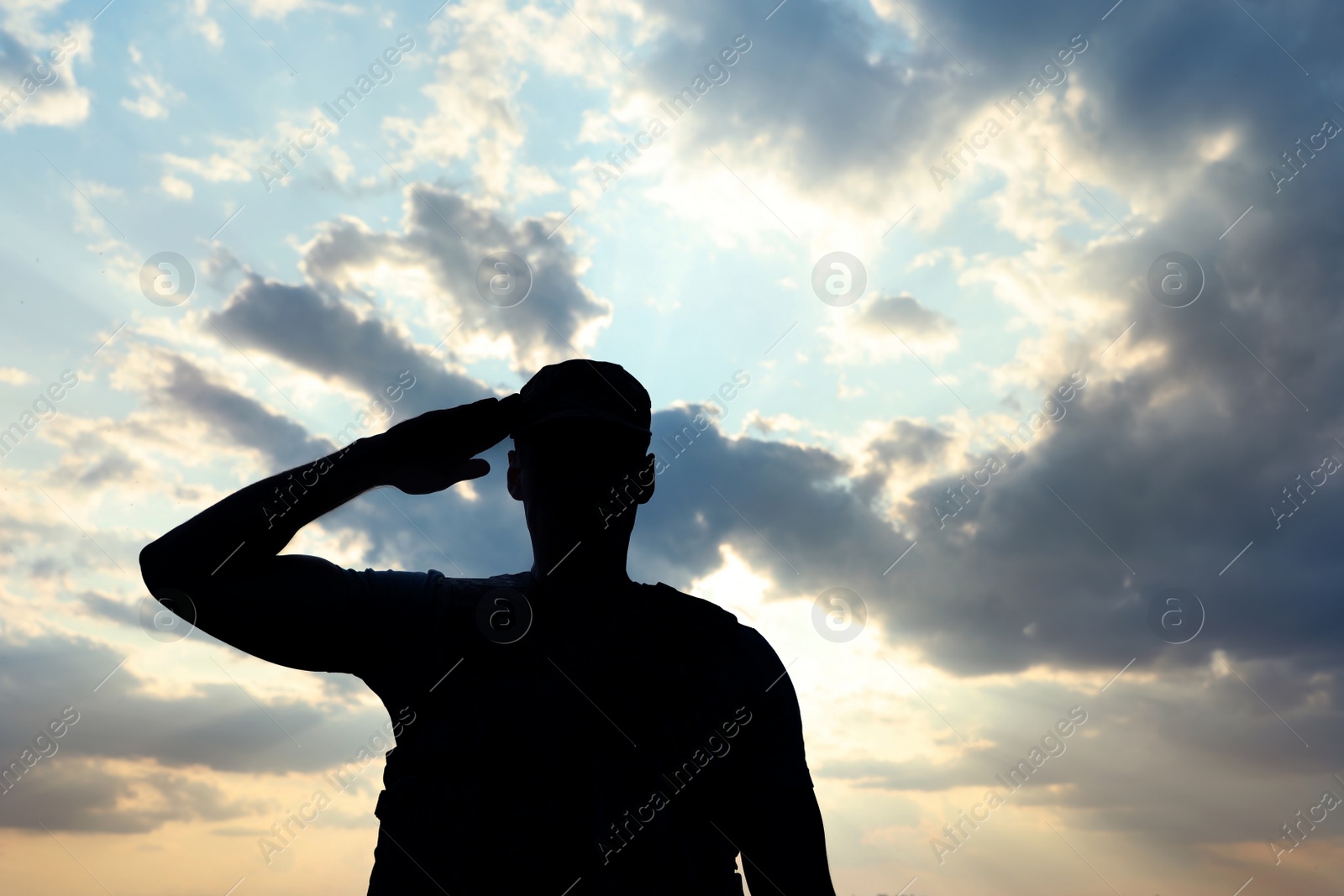 Photo of Soldier in uniform saluting outdoors. Military service