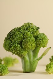 Photo of Fresh raw broccoli on beige background, closeup