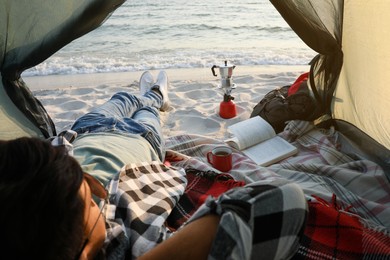 Photo of Man resting in camping tent near sea, closeup