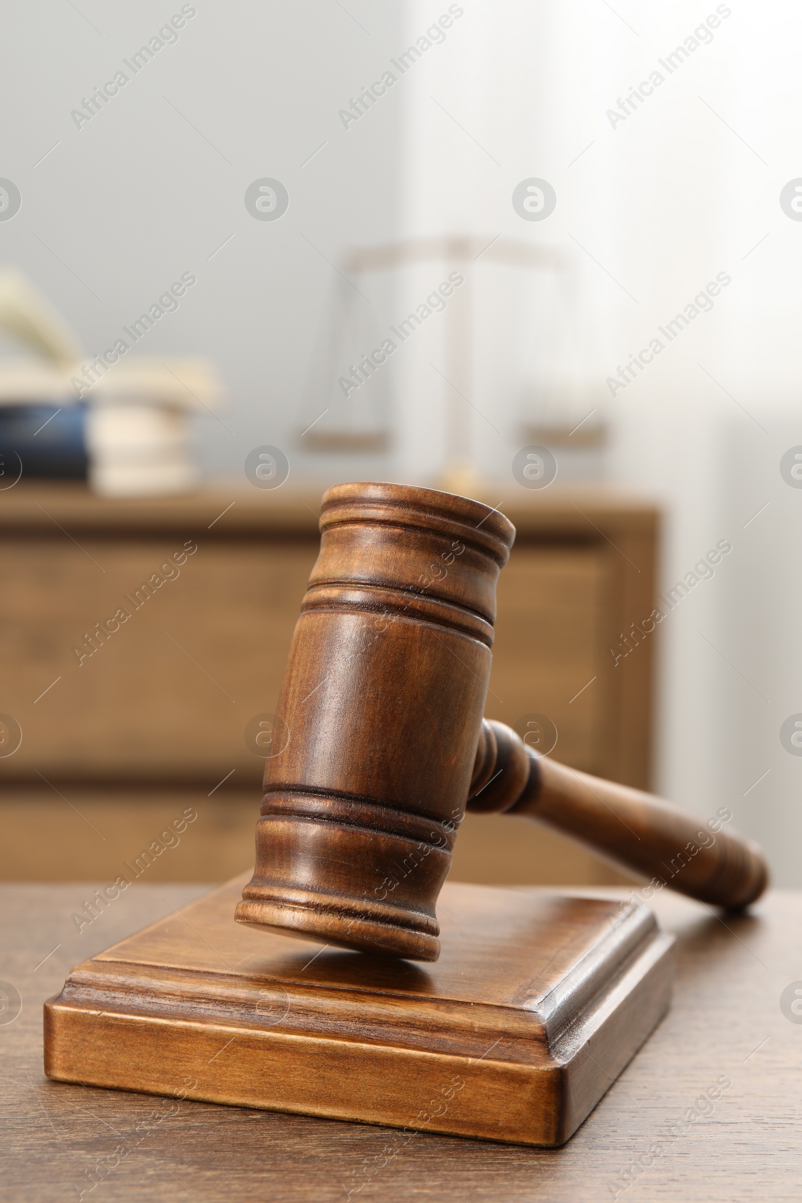 Photo of Wooden gavel and sound block on table indoors, closeup. Space for text