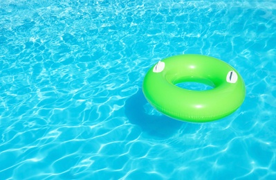 Photo of Inflatable ring floating in swimming pool on sunny day. Space for text