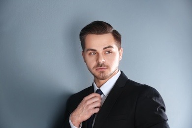 Portrait of young man with beautiful hair on grey background