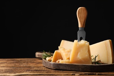 Photo of Delicious parmesan cheese with rosemary on wooden table. Space for text