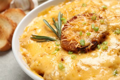 Photo of Tasty homemade French onion soup in bowl, closeup