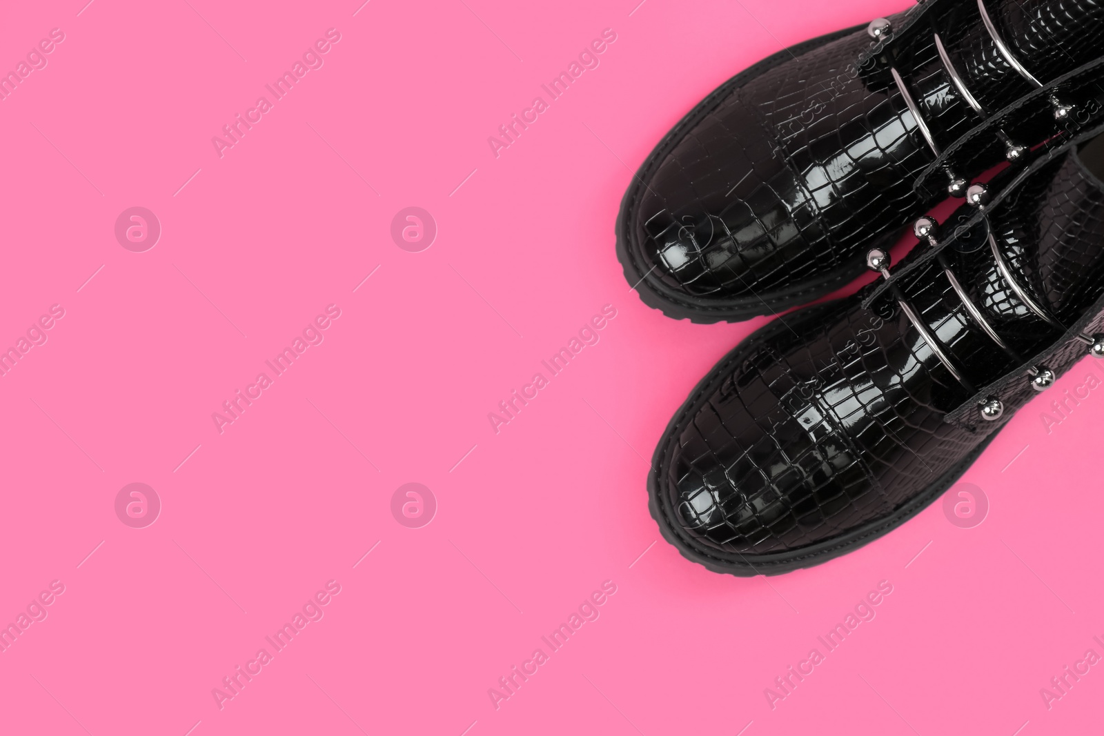 Photo of Pair of stylish ankle boots on pink background, top view. Space for text