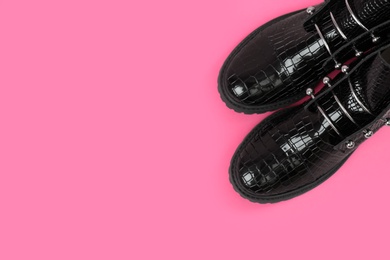 Pair of stylish ankle boots on pink background, top view. Space for text