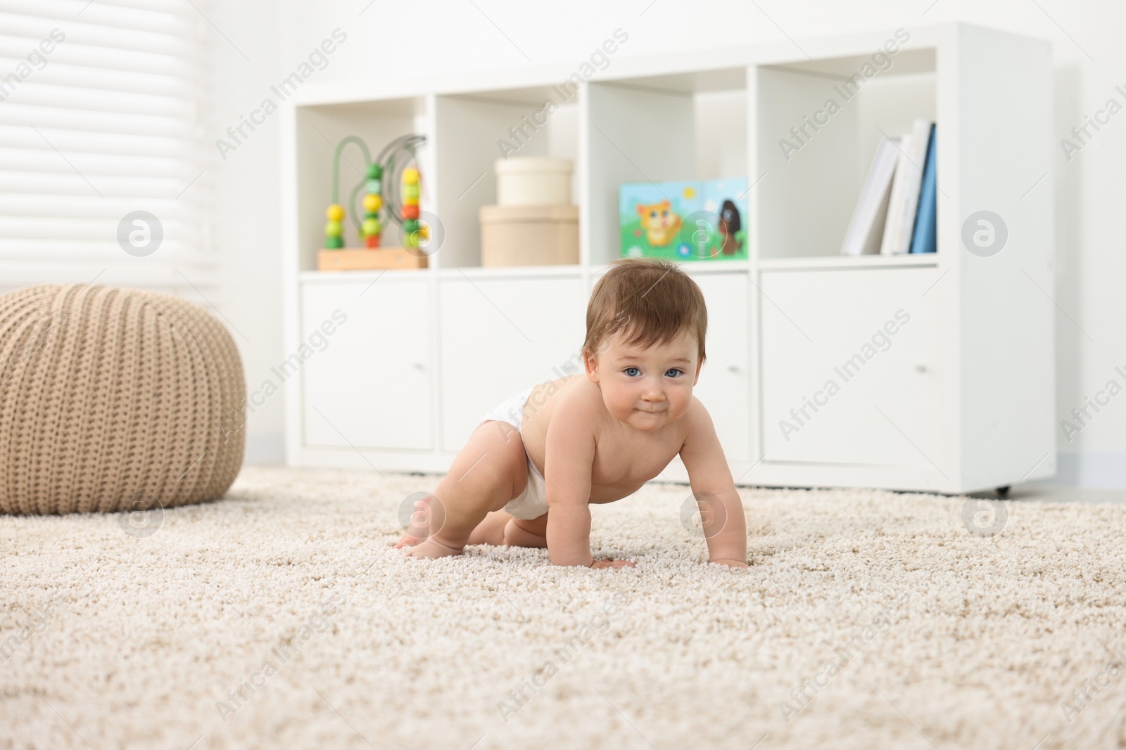 Photo of Cute baby boy crawling on carpet at home