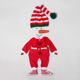 Photo of Creative snowman shape made of Santa elf's hat, red suit and different items on white background, flat lay