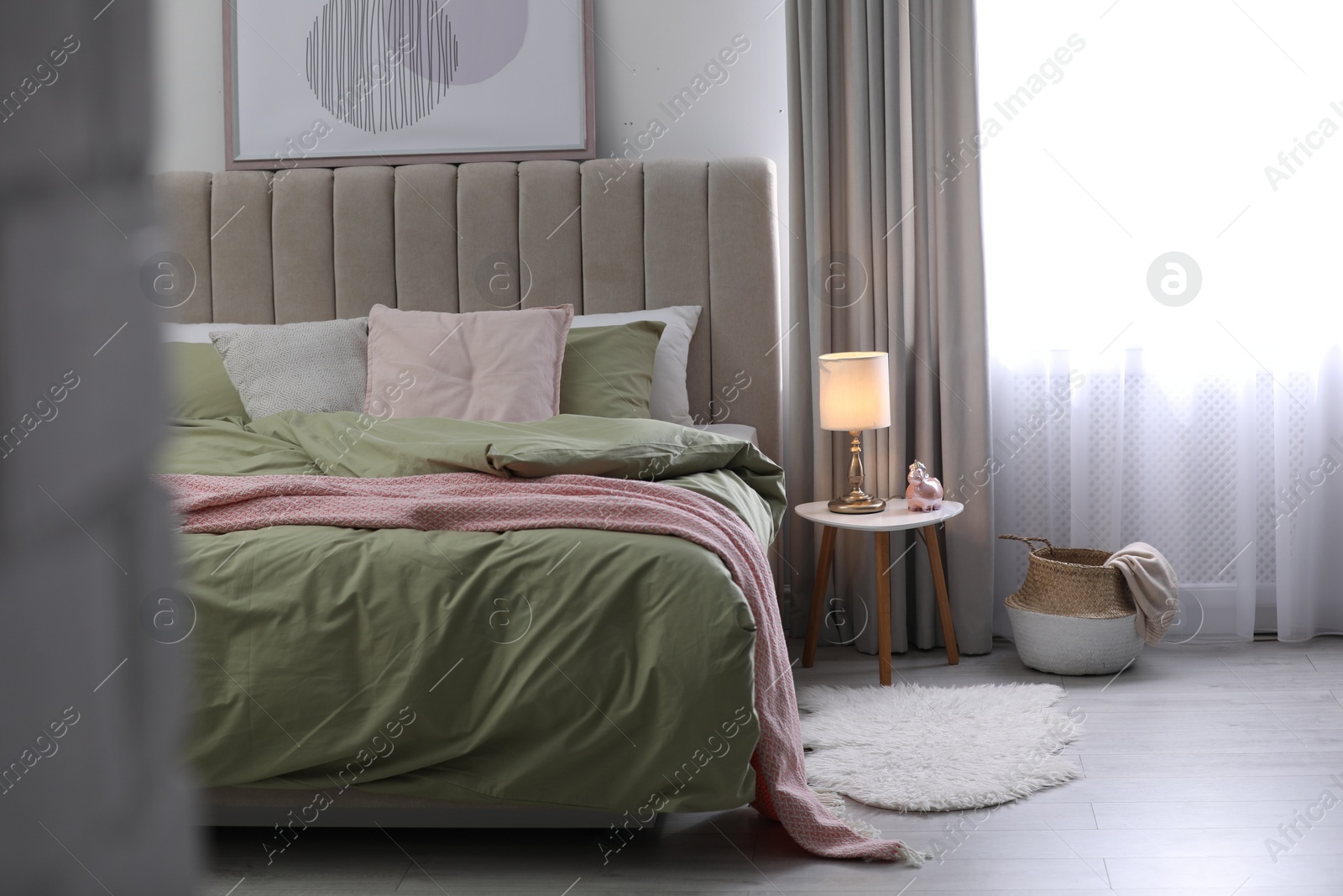 Photo of Comfortable bed with new pistachio linens in modern room interior