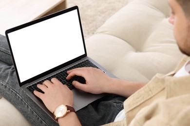 Man working with laptop on sofa indoors, closeup