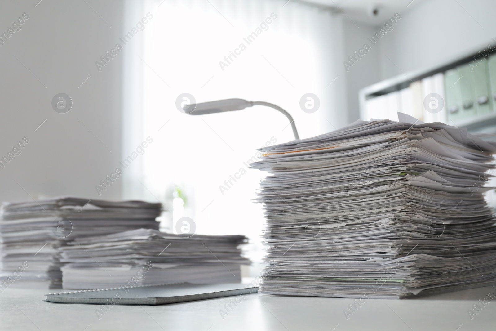 Photo of Stacks of documents on desk in office