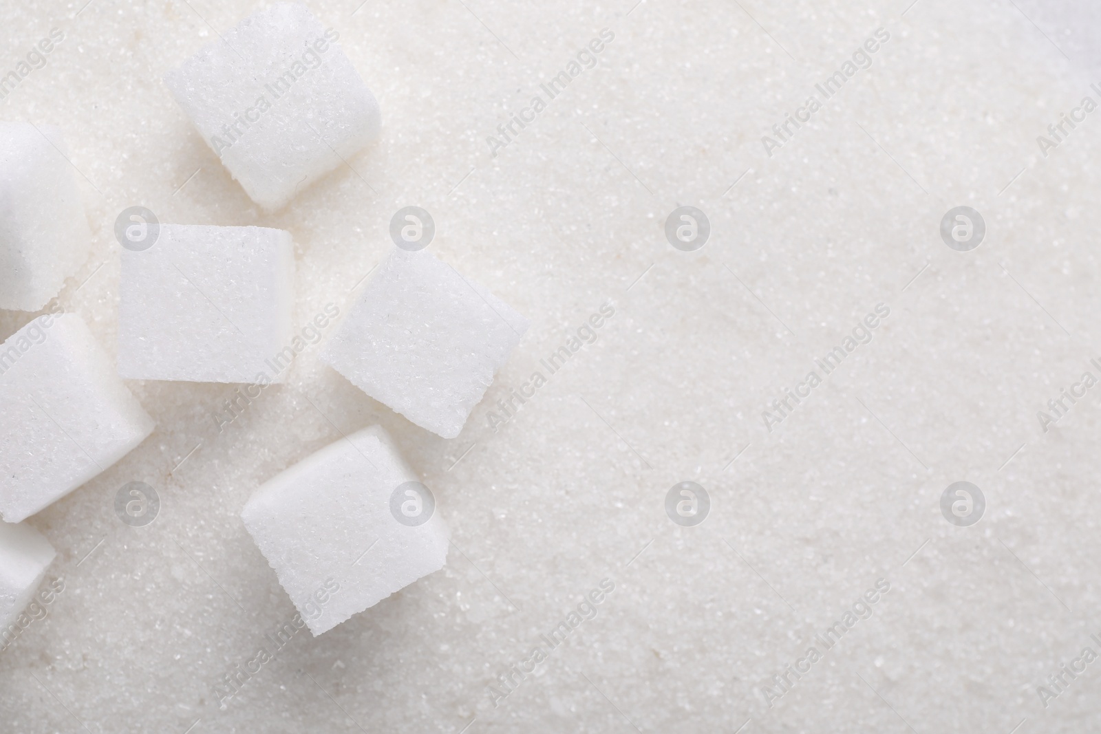 Photo of Different types of sugar as background, top view. Space for text