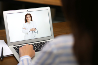 Image of Woman using laptop for online consultation with mature female doctor, closeup 