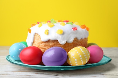 Photo of Easter cake and colorful eggs on white wooden table