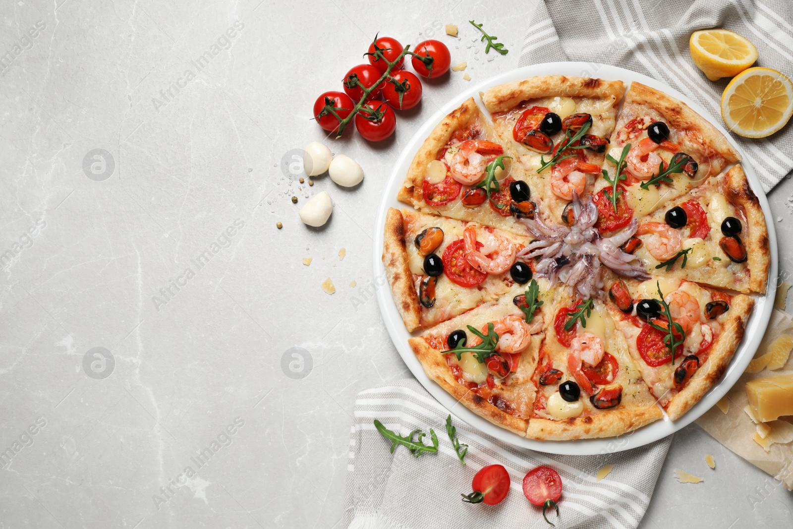 Photo of Tasty pizza with seafood and ingredients on light grey marble table, flat lay. Space for text