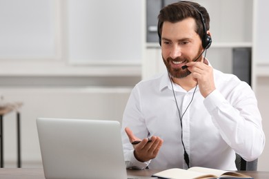 Photo of Hotline operator with headset working in office