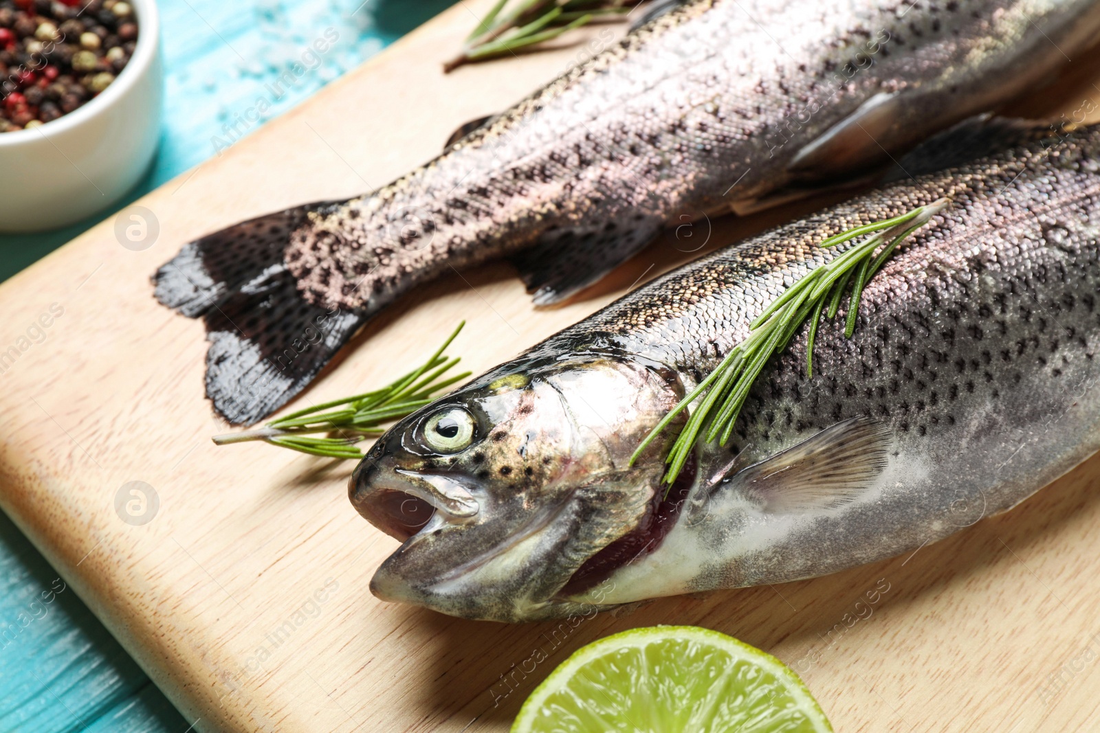 Photo of Raw cutthroat trout fish on wooden board, closeup