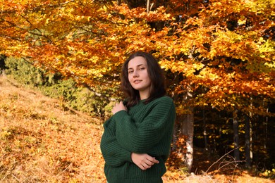 Photo of Portrait of beautiful young woman near forest in autumn