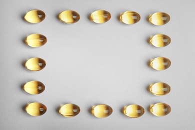 Photo of Frame of cod liver oil pills with space for text on white background, top view