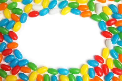 Photo of Frame of jelly beans on white background, top view. Space for text