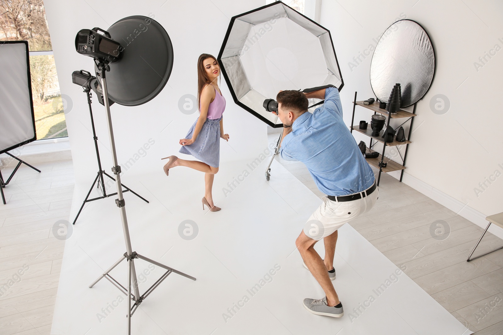 Photo of Beautiful young model posing for professional photographer in studio