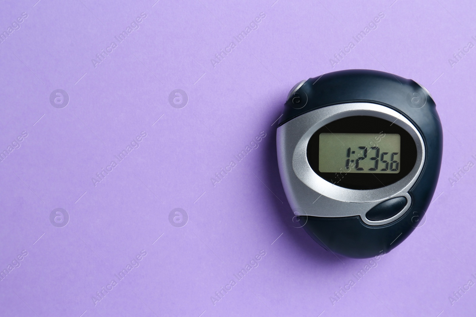 Photo of Digital timer on violet background, top view. Space for text
