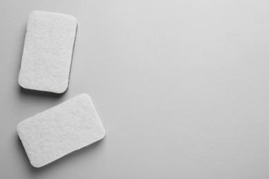 Photo of New sponges on light grey background, flat lay. Space for text