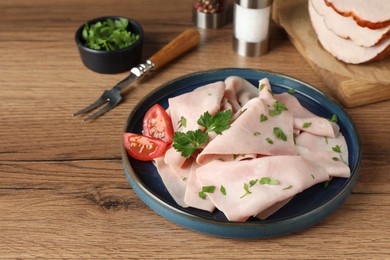 Photo of Delicious ham slices with parsley and tomato on wooden table