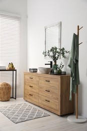 Photo of Modern bathroom interior with stylish mirror, eucalyptus branches, vessel sink and wooden vanity