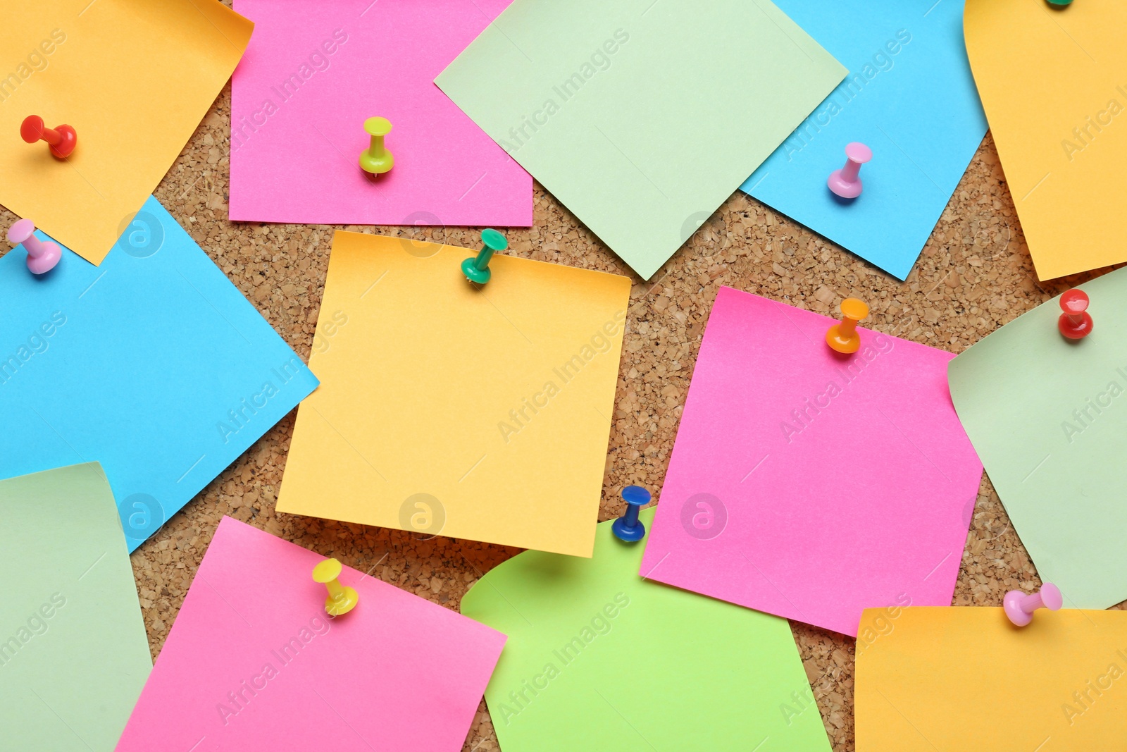 Photo of Many blank colorful notes pinned to corkboard. Space for text