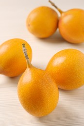 Photo of Delicious ripe granadillas on white wooden table, closeup