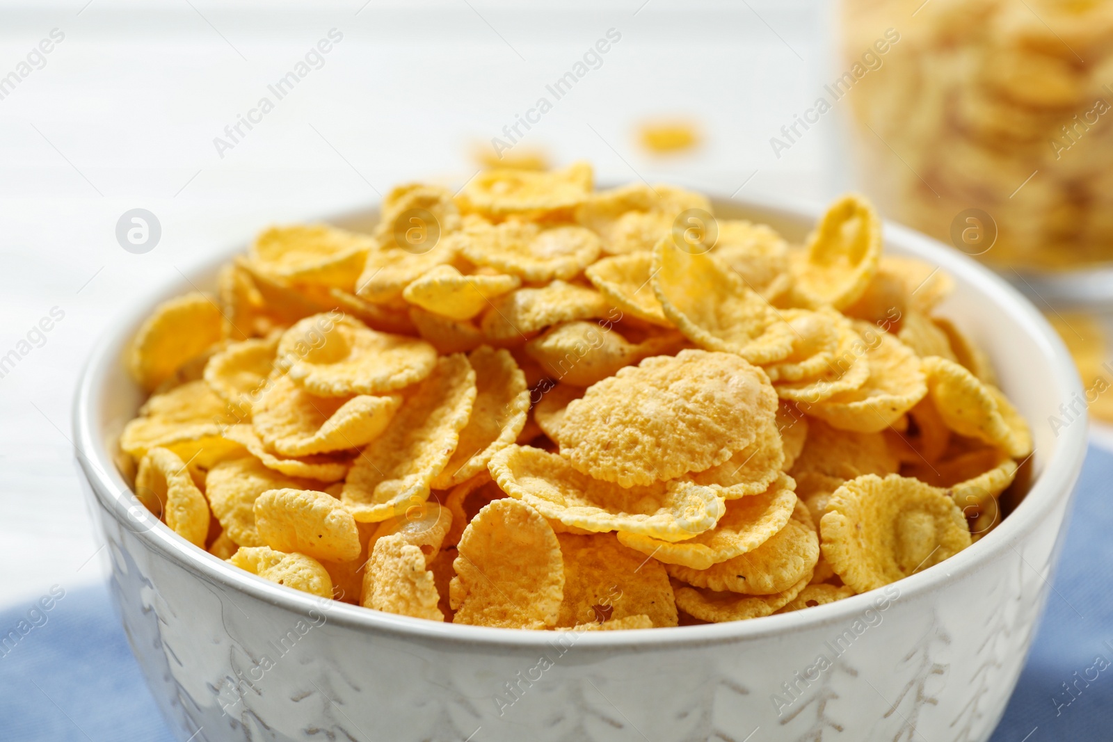 Photo of Tasty corn flakes on white table, closeup