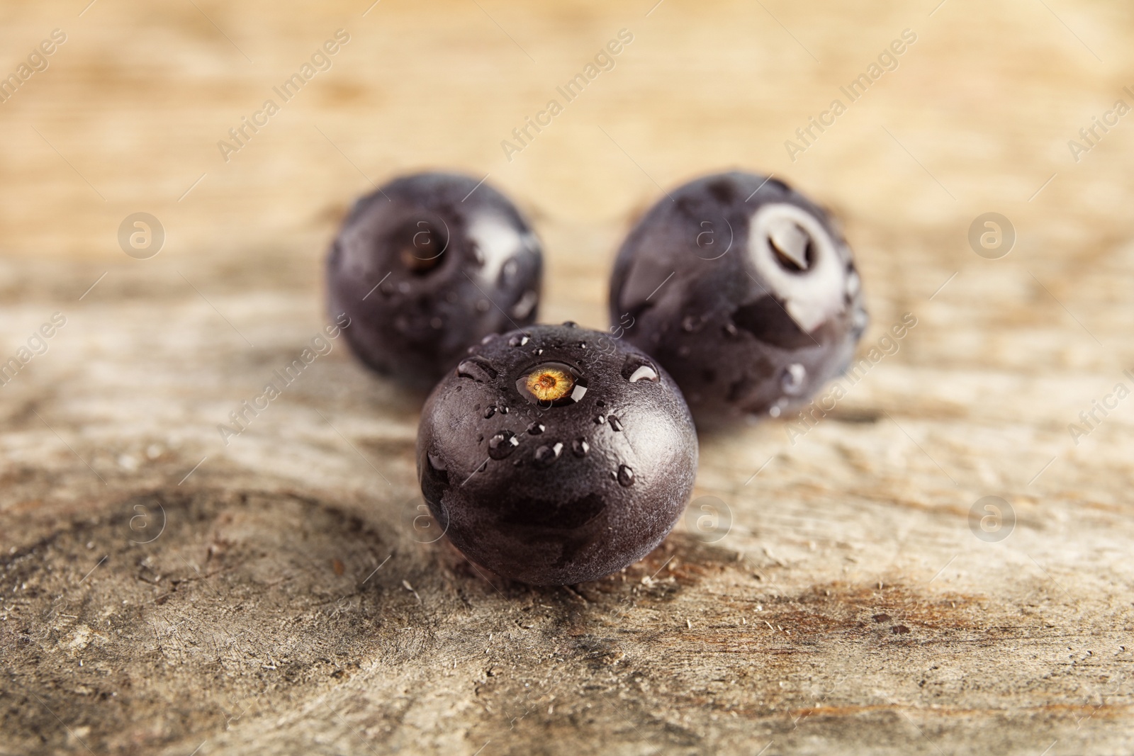 Photo of Fresh acai berries on wooden table, closeup