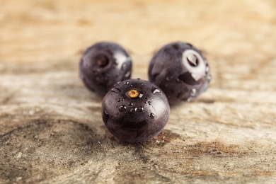 Photo of Fresh acai berries on wooden table, closeup