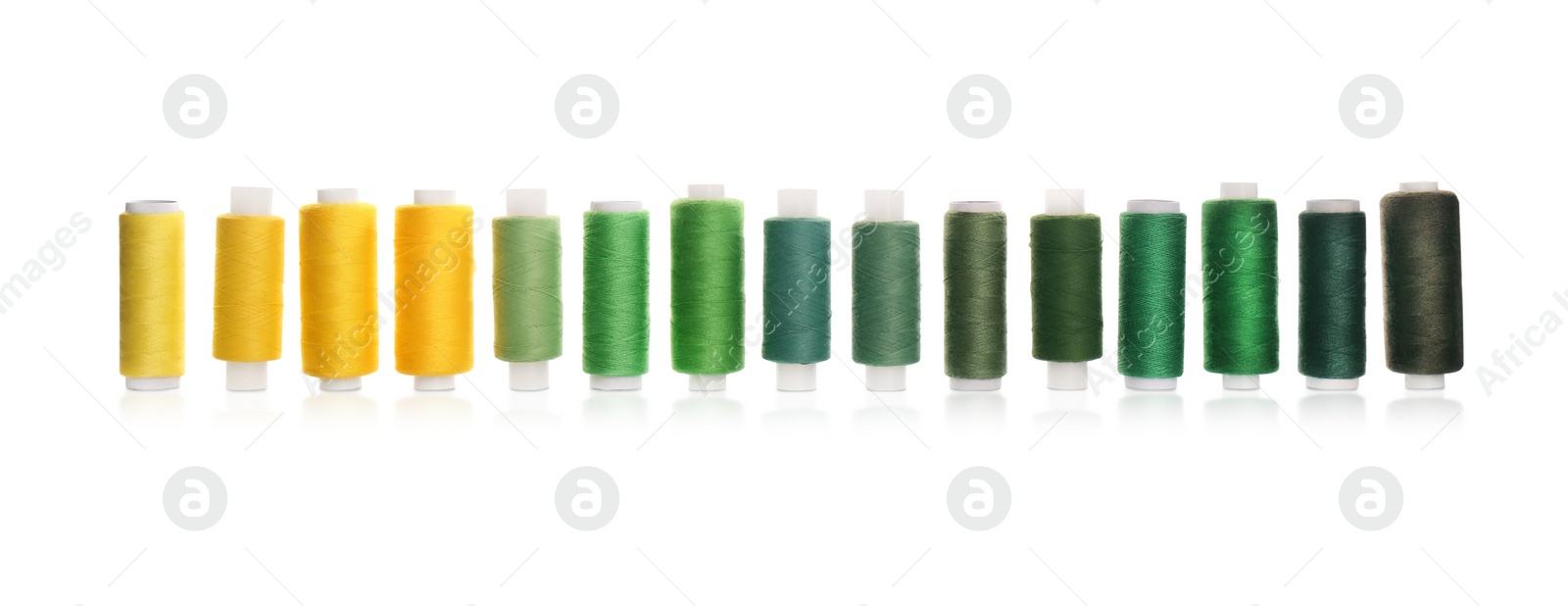 Photo of Set of colorful sewing threads on white background