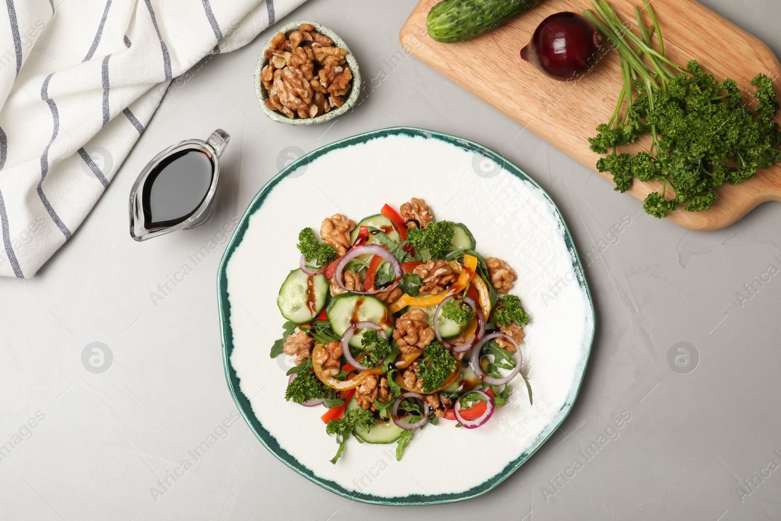 Photo of Vegetable salad served with balsamic vinegar on grey background, top view